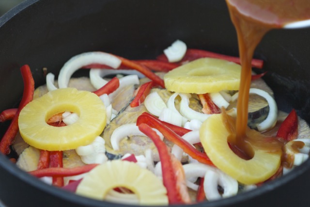 Pouring the sweet and sour sauce over the ham steaks