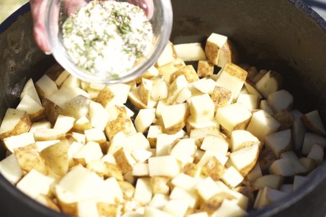 Adding seasoning to Idaho potatoes in Dutch oven | Cooking-Outdoors.com | Gary House