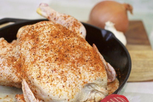 Whole chicken on bed of onion in a cast iron skillet | Cooking-Outdoors.com | Gary House