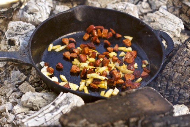 Adding onions to the linguica | Cooking-Outdoors.com | Gary House