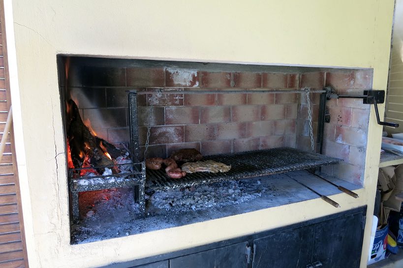 Typical Argentine grill with crank and fire on the side |Authentic Food Quest
